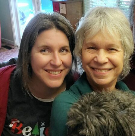 Two smiling people with small dog