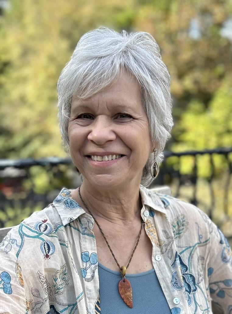 Smiling gray-haired woman outdoors wearing pendant