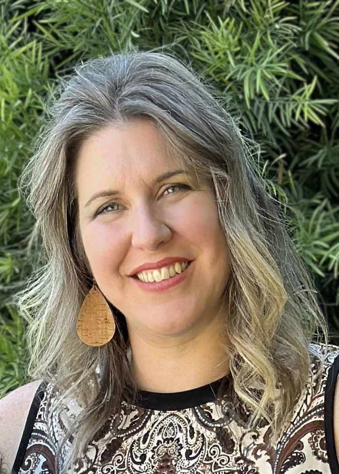 Smiling woman with wavy gray hair outdoors