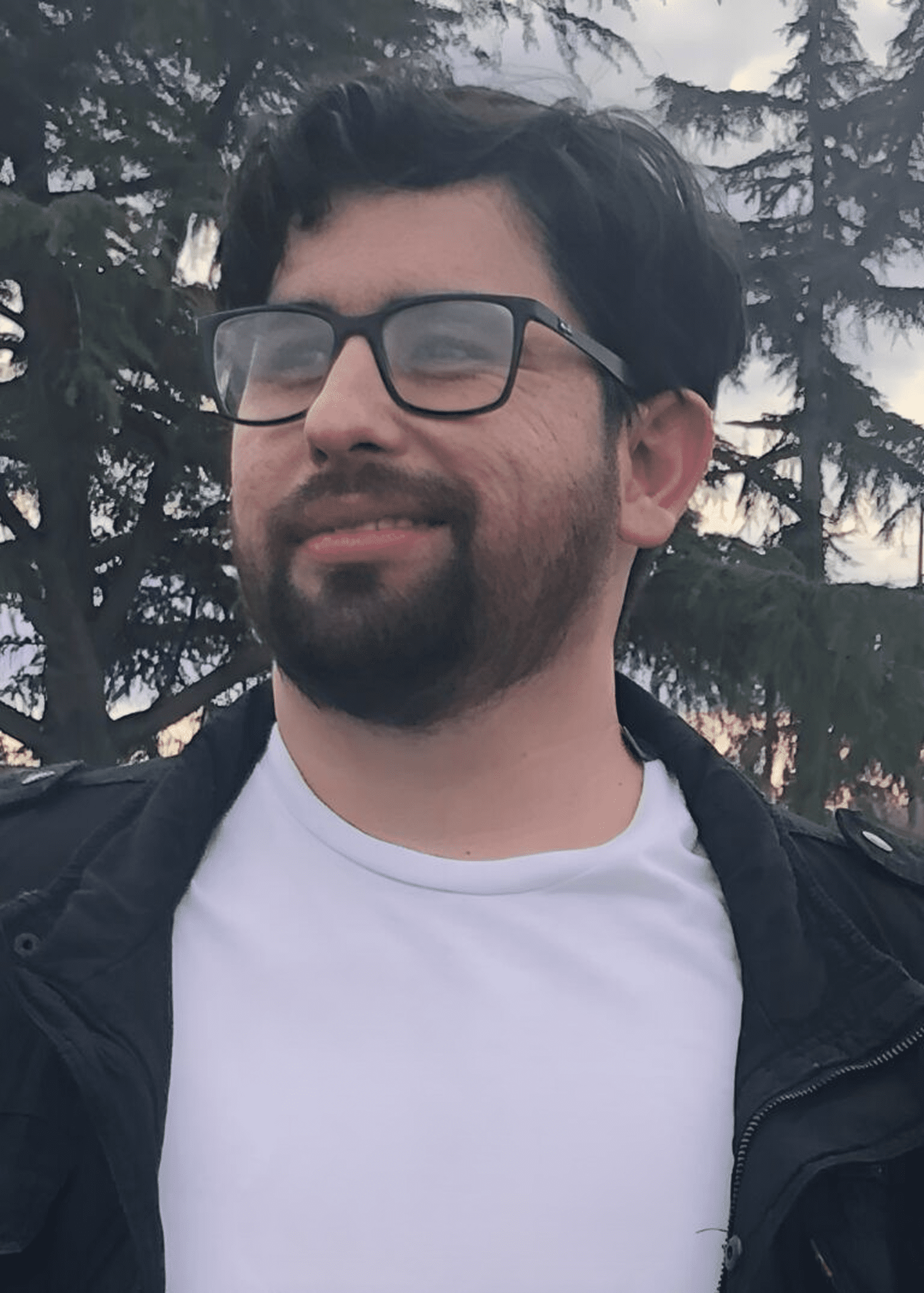 Smiling bearded man wearing glasses outdoors