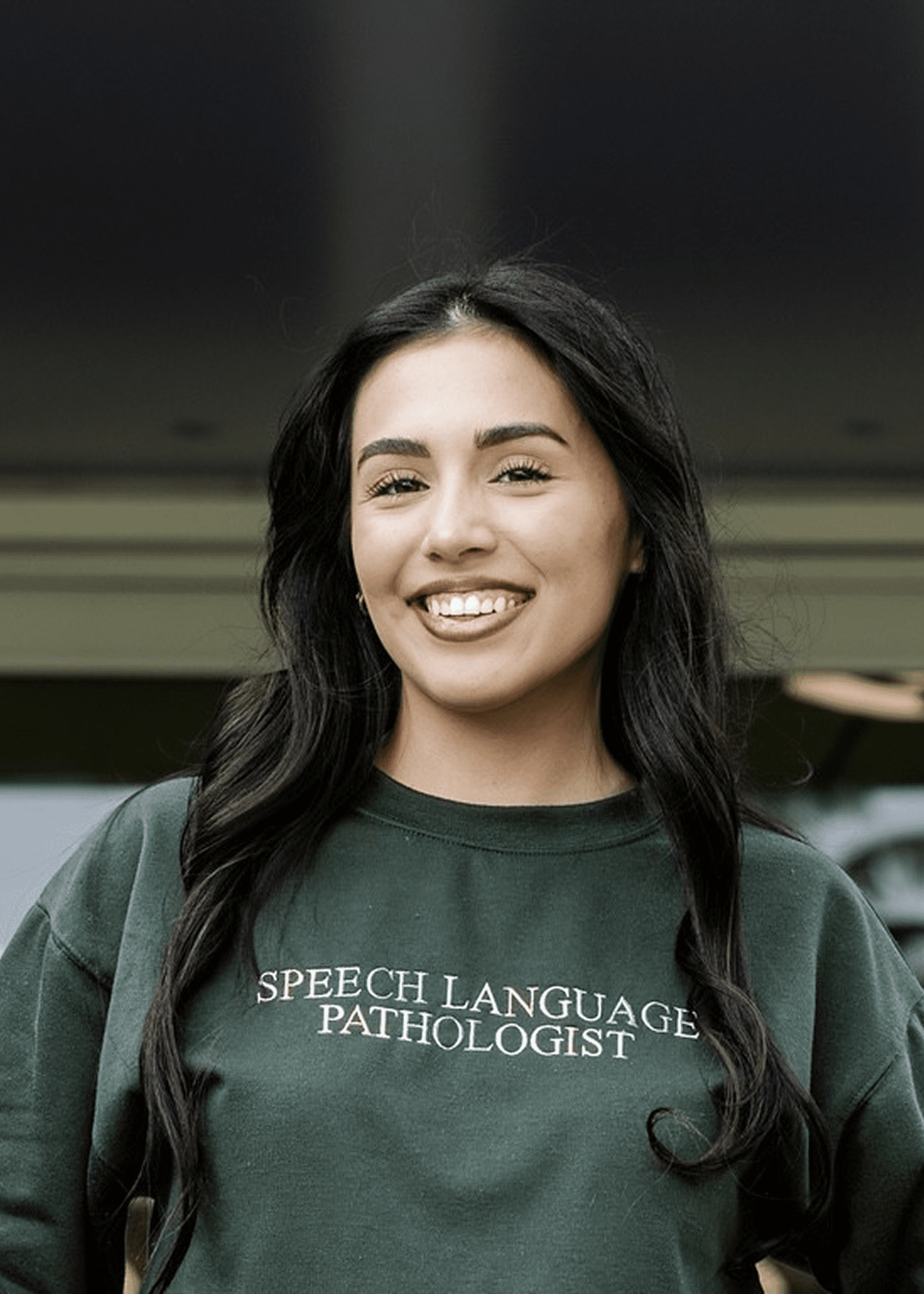 Smiling woman wearing speech language pathologist sweatshirt