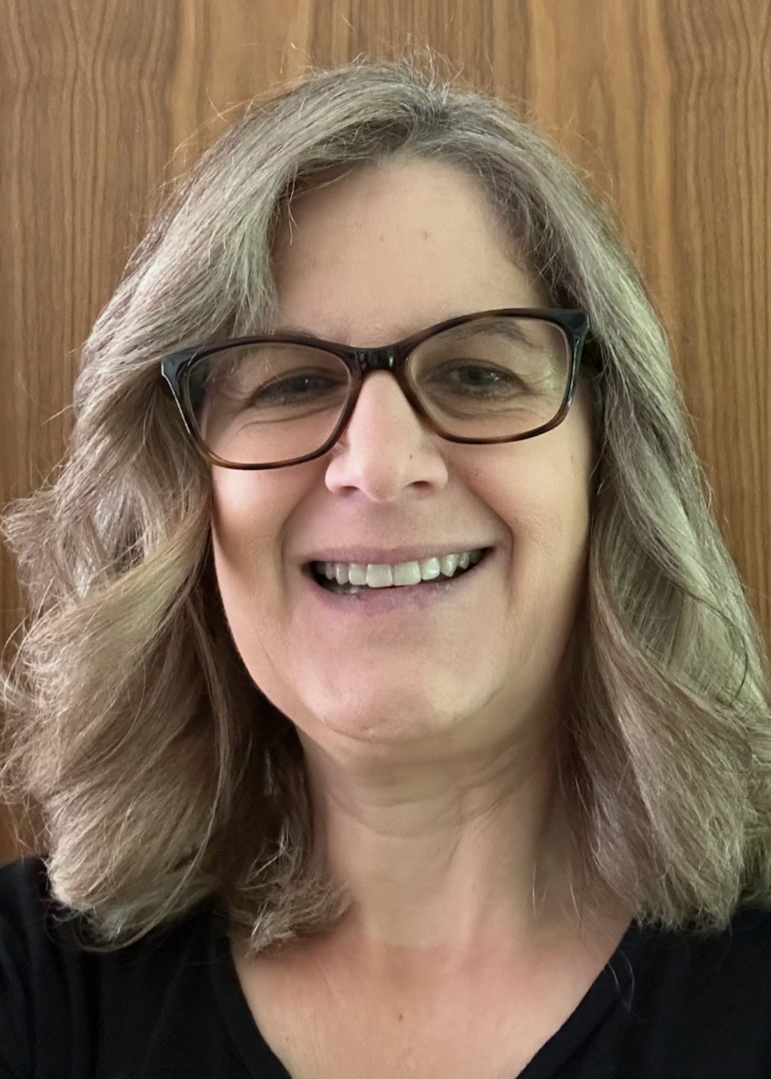 Smiling woman with glasses and wavy hair